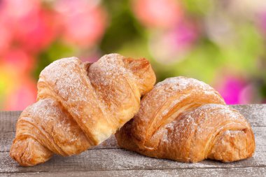 iki ay çöreği bulanık bir bahçe arka plan ile ahşap bir gemide pudra şekeri serpilir