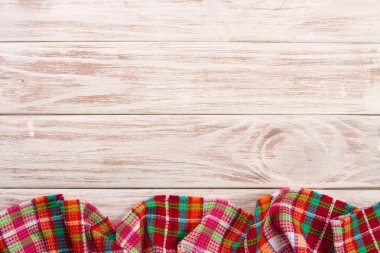 Metniniz için kopya alanı ile ışık ahşap bir masa üzerinde kırmızı kareli masa örtüsü. Üstten Görünüm