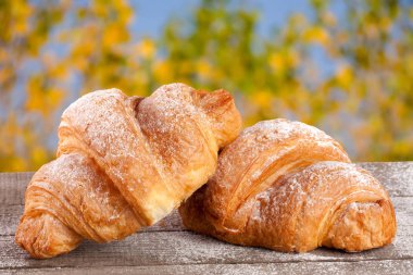 iki ay çöreği bulanık bir bahçe arka plan ile ahşap bir gemide pudra şekeri serpilir