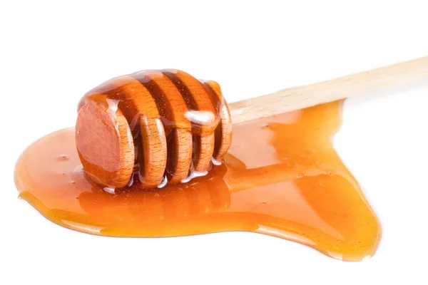 Honey stick s tekoucí zlato izolované na bílém pozadí — Stock fotografie