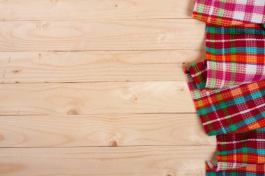 Metniniz için kopya alanı ile ışık ahşap bir masa üzerinde kırmızı kareli masa örtüsü. Üstten Görünüm