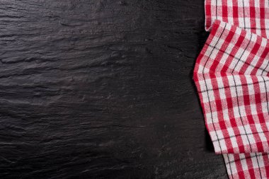 Kopya alanı metniniz için karanlık bir taş zemin üzerine kırmızı kareli masa örtüsü. Üstten Görünüm