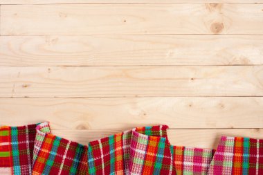 Metniniz için kopya alanı ile ışık ahşap bir masa üzerinde kırmızı kareli masa örtüsü. Üstten Görünüm
