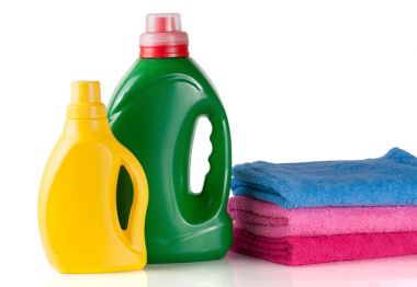 şişe çamaşır deterjanı ve saç kremi veya yumuşatıcı beyaz arka plan üzerinde izole havlu ile