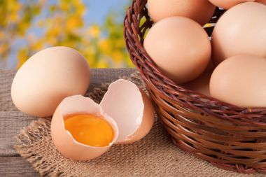 Bahçe arka plan bulanık ile ahşap bir gemide bir hasır sepet yumurta