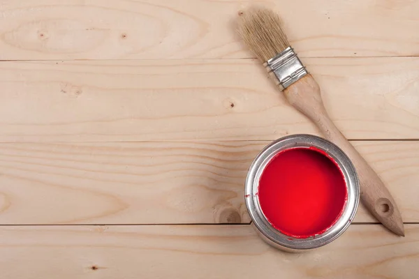 Red paint in the bank to repair and brush on the light wooden background with copy space for your text. Top view — Stock Photo, Image