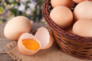 Bahçe arka plan bulanık ile ahşap bir gemide bir hasır sepet yumurta