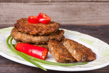 karaciğer krep veya pirzola chili biber ve ahşap bir zemin üzerine yeşil soğan ile