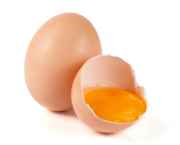 Jedno hnědé vajíčko a rozbité vajíčko izolovaných na bílém pozadí — Stock fotografie