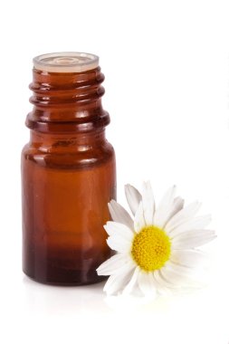 Beyaz arka planda özgün yağ ve taze papatya çiçekleri bulunan şişe.