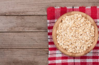 Kopya alanı metniniz için eski ahşap zemin üzerine ahşap bir kase yulaf gevreği. Üstten Görünüm