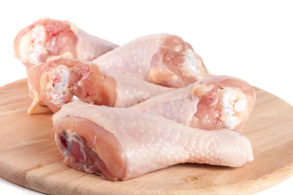 Cosce di pollo crude su un tagliere di legno sfondo bianco — Foto Stock