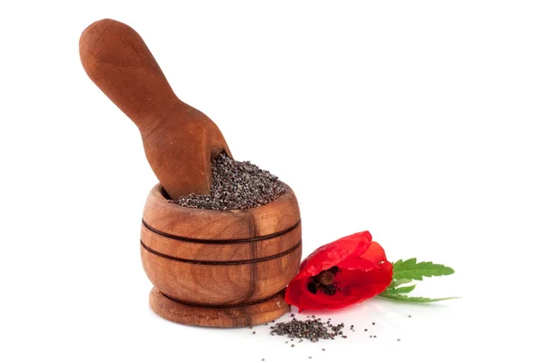 Семена мака в деревянной чаше и совок с цветком — стоковое фото