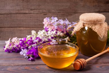 Kavanoz bal ile kır çiçekleri koyu ahşap arka plan üzerinde