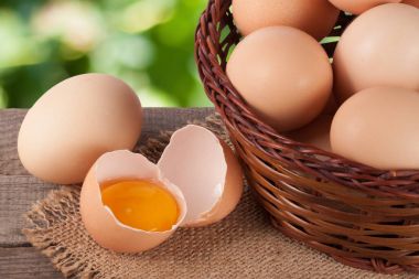 Bahçe arka plan bulanık ile ahşap bir gemide bir hasır sepet yumurta