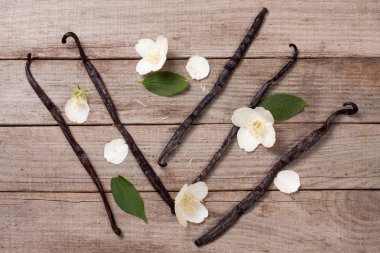Çiçek ve yaprak eski ahşap zemin ile vanilya çubukları