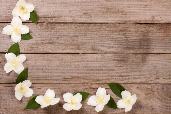 Eski ahşap arka plan kopya alanı metni ile çerçeve Yasemin çiçekleri. Üstten Görünüm. Düğün davetiye kartı