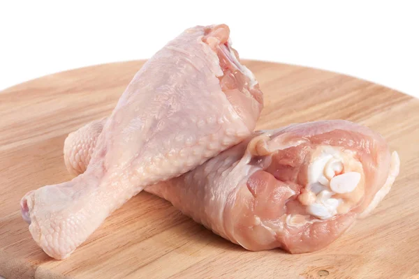 Dvě syrová kuřecí stehna na krájecí boardn bílé pozadí — Stock fotografie