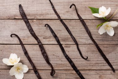 Çiçek ve yaprak eski ahşap zemin ile vanilya çubukları