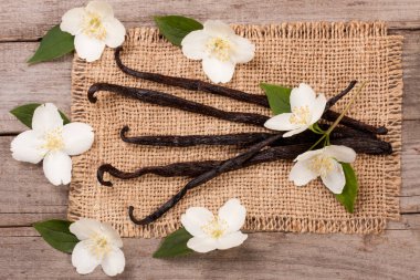 Çiçek ve yaprak eski ahşap zemin ile vanilya çubukları