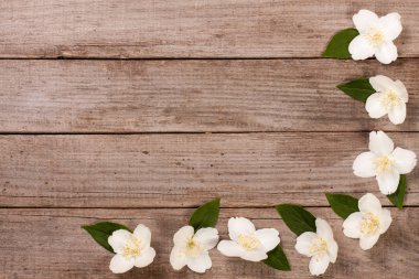 Eski ahşap arka plan kopya alanı metni ile çerçeve Yasemin çiçekleri. Üstten Görünüm. Düğün davetiye kartı