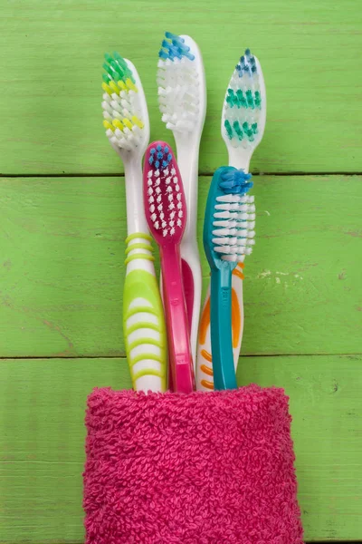 Toothbrushes on the green wooden background — Stock Photo, Image