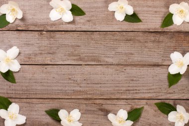 Eski ahşap arka plan kopya alanı metni ile çerçeve Yasemin çiçekleri. Üstten Görünüm. Düğün davetiye kartı