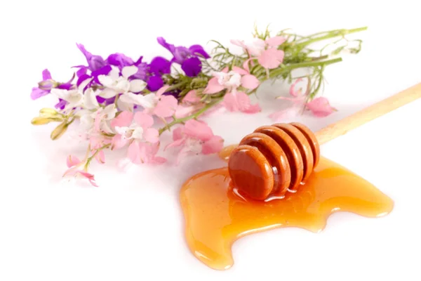 Méz stick áramló mézzel és wildflowers elszigetelt fehér background — Stock Fotó
