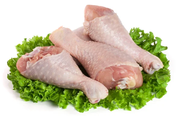 Três baquetas de frango cru com folha de alface isolada no fundo branco — Fotografia de Stock