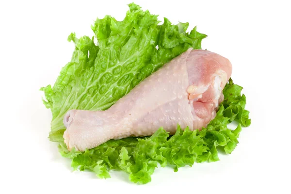Raw chicken drumstick with lettuce leaf isolated on white background Stock Picture