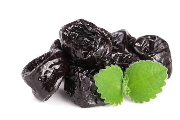 Heap of dried plums or prunes with a mint leaf isolated on white background — Stock Photo, Image