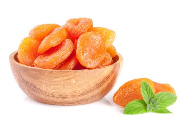 Beyaz arka plan üzerinde izole nane yaprakları ile ahşap bir kase kuru kayısı