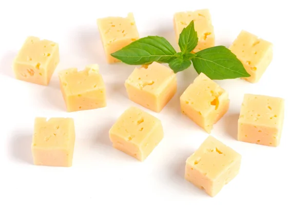 Cheese cut into cubes with basil leaves isolated on white background — Stock Photo, Image