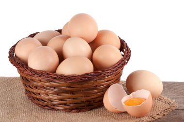 yumurta bir hasır sepet beyaz zemin üzerinde bir ahşap tablo