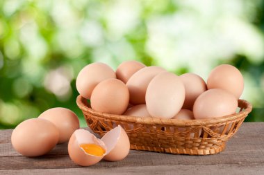 Bahçe arka plan bulanık ile ahşap bir gemide bir hasır sepet yumurta