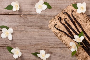 Çiçek ve yaprak üzerinde eski bir ahşap arka plan w ile vanilya çubukları