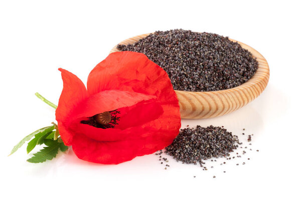 Poppy seeds in a wooden bowl with a flower