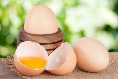 Bahçe arka plan bulanık bir tahta üzerinde ahşap bir kasede yumurta