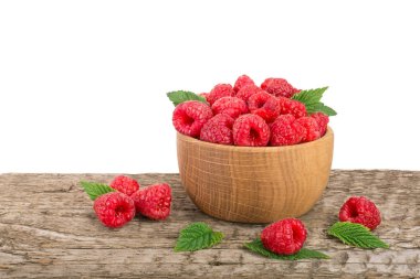 Beyaz arka plan ile masada ahşap bir kabın içinde ahududu