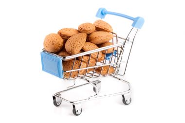 Beyaz arka plan üzerinde izole badem ile alışveriş sepeti