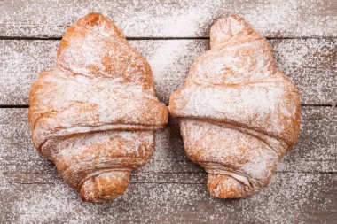 eski ahşap tahta üzerinde pudra şekeri serpilir iki ay çöreği