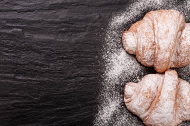 iki ay çöreği kopya alanı metni siyah taş zemin üzerine pudra şekeri serpilir. Üstten Görünüm