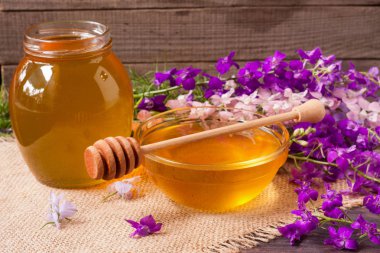 Kavanoz bal ile kır çiçekleri koyu ahşap arka plan üzerinde