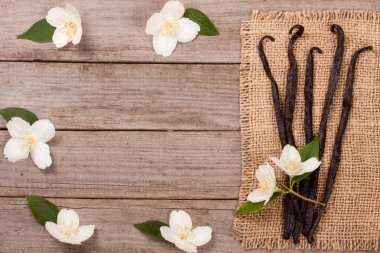Çiçek ve yaprak üzerinde eski bir ahşap arka plan w ile vanilya çubukları