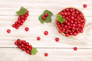 Frenk üzümü çilek yaprak hafif ahşap arka plan üzerinde ahşap bir kase. Üstten Görünüm