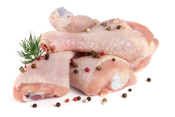 Three raw chicken drumsticks with a sprig of dill and peppercorns isolated on white background — Stock Photo, Image