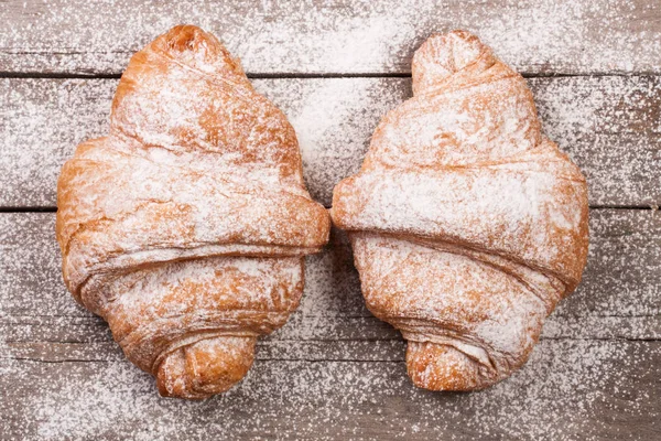 eski ahşap tahta üzerinde pudra şekeri serpilir iki ay çöreği