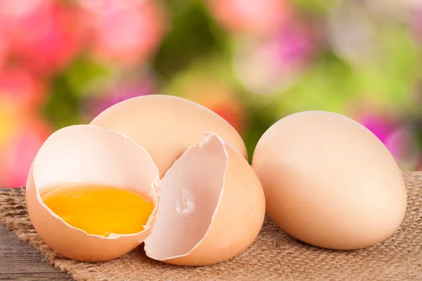 Uovo rotto con tuorlo e guscio d'uovo Su un tavolo di legno con sfocatura — Foto Stock