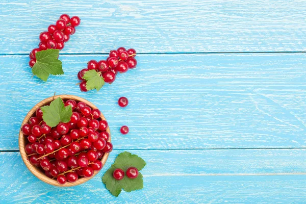 Frenk üzümü meyveleri mavi woode yaprağına bir ahşap kase