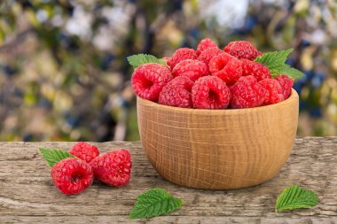 Ahududu ahşap bir kase bulanık bir bahçe backgro tablo